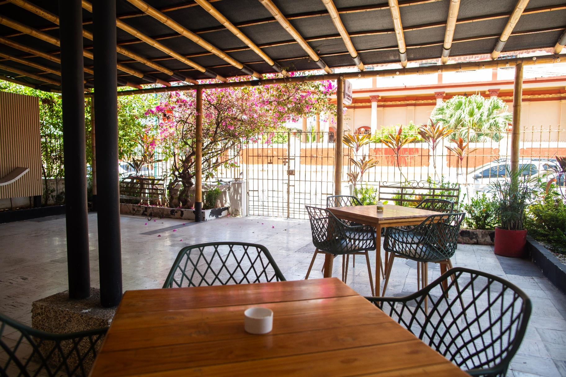 Vista amplia de la terraza cubierta con techo de bambú y buganvilias